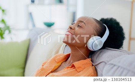Calm woman, music and headphones in home for listening to audio, radio and hearing podcast on sofa. Happy african person relax for streaming sound, multimedia and peaceful subscription in living room Calm woman, music and headphones in home for listening to audio, radio and hearing podcast on sofa. Happy african person relax for streaming sound, multimedia and peaceful subscription in living room 138104513