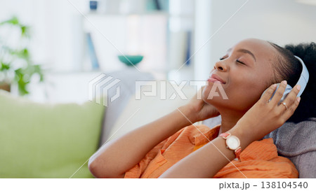 Music headphones, relax or black woman on couch streaming a song or calm sound on radio playlist. African girl, peace or happy zen person listening to a podcast audio on subscription on home sofa Music headphones, relax or black woman on couch streaming a song or calm sound on radio playlist. African girl, peace or happy zen person listening to a podcast audio on subscription on home sofa 138104540