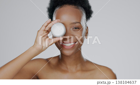 Face, model and hands with eye cream for cosmetic, hand gesture and beautiful skin in studio background. Black woman, moisturizer and serum for dermatology with self care portrait and smile in mockup Face, model and hands with eye cream for cosmetic, hand gesture and beautiful skin in studio background. Black woman, moisturizer and serum for dermatology with self care portrait and smile in mockup 138104637