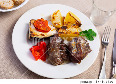 Baked pork cheeks with vegetables and greens on plate Baked pork cheeks with vegetables and greens on plate 138105139