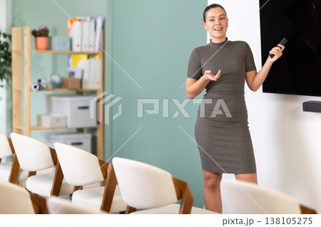 Girl teacher speaker with remote control during lecture 138105275