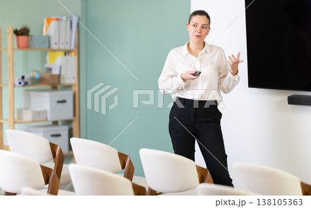 Girl teacher speaker with remote control during lecture 138105363