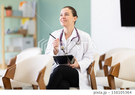 Female medical student listening to lecture in classroom with tablet 138105364