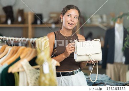 Woman choosing handbags in the store Woman choosing handbags in the store 138105383