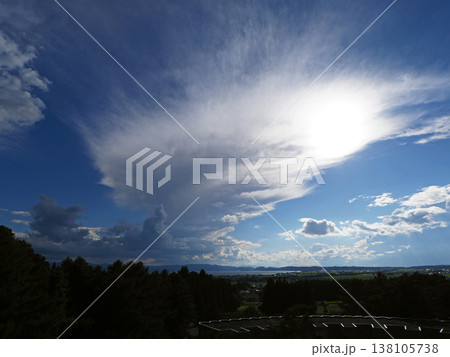 夏の午後、猪苗代湖上空にに湧き上がる白い積乱雲。雲が太陽で白く輝き、湖面も輝きく。印象的で綺麗だ。 138105738