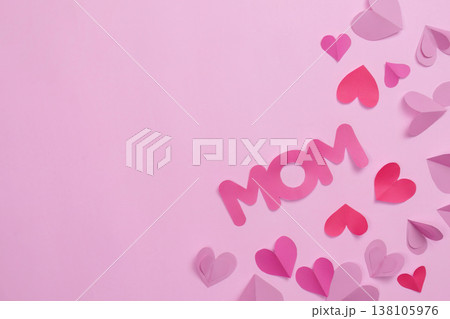 Pink paper hearts and 'Mom' text on pastel background 138105976