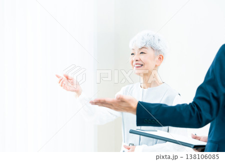 営業マンの説明を聞くシニア女性 138106085