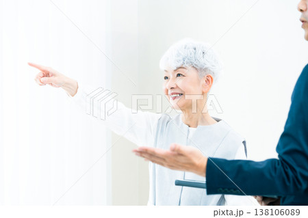 営業マンの説明を聞くシニア女性 138106089