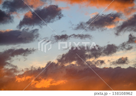 Sky at dusk showing rich orange glow against deep blue with textured clouds Sky at dusk showing rich orange glow against deep blue with textured clouds 138108962