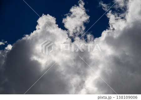 Powerful cumulus clouds tower above dark blue heavens 138109006