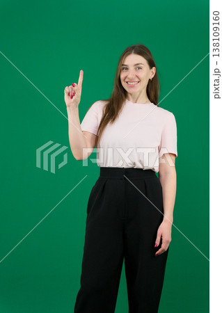 Pretty young woman showing peace gesture different emotions of a young girl on a green background chromakey beautiful facial features real people pink T-shirt white skinned European. black flared wide Pretty young woman showing peace gesture different emotions of a young girl on a green background chromakey beautiful facial features real people pink T-shirt white skinned European. black flared wide 138109160