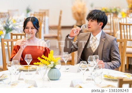 結婚式場,披露宴会場で食事をするドレス,スーツ姿の男女カップル 138109243