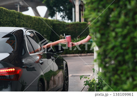 Hand Man in car receiving coffee in drive thru fast food restaurant.  138109961