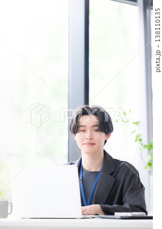 パソコンに向かう若いビジネスマンカメラ目線 若手社員の爽やかな成長と成功のビジネスシーン パソコンに向かう若いビジネスマンカメラ目線 若手社員の爽やかな成長と成功のビジネスシーン 138110135