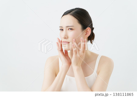 白背景の肌荒れを気にする若い女性 白背景の肌荒れを気にする若い女性 138111865