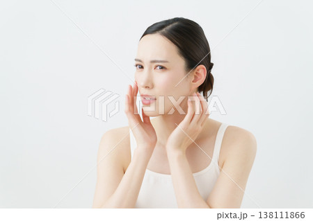 白背景の肌荒れを気にする若い女性 白背景の肌荒れを気にする若い女性 138111866