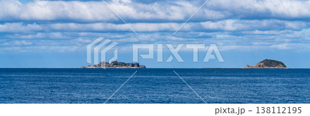 青空の下、遠くの海に浮かぶ軍艦島の全景 138112195