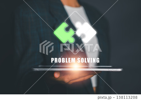 Businessperson holding tablet with puzzle pieces, symbolizing problem solving and innovation in technology. 138113208