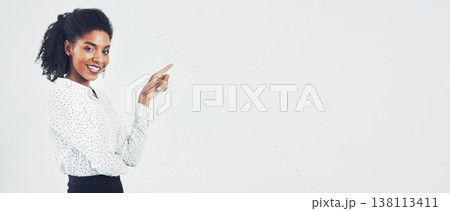Pointing, mockup and portrait of happy businesswoman in studio with empty space for marketing or advertising. Banner, smile and professional person with show gesture for mock up by white background. 138113411