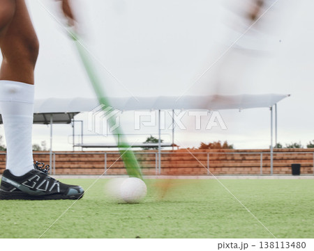 Person, legs and hockey stick on field, ball with speed or motion for sports goal, training or professional game. Action, feet and turf with performance for outdoor competition, fitness and exercise 138113480