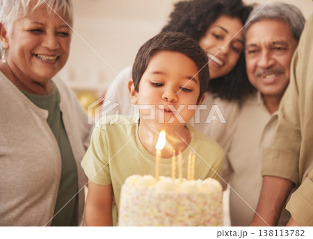 Birthday party, happy family and child with cake blowing candle in a home for event to celebrate together in a house. Grandparents, happiness and kid excited for gathering, surprise and gift 138113782