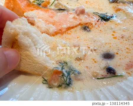 クラムチャウダー。アサリと鮭の切り身が入ったホワイトシチュー。トーストをつけて食べる。 クラムチャウダー。アサリと鮭の切り身が入ったホワイトシチュー。トーストをつけて食べる。 138114345