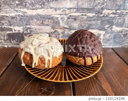 チョコレートでコーティングしたエクレアのようなシュークリーム。 チョコレートでコーティングしたエクレアのようなシュークリーム。 138114398