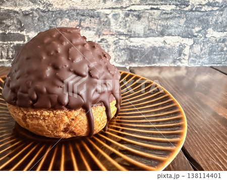 チョコレートでコーティングしたエクレアのようなシュークリーム。 チョコレートでコーティングしたエクレアのようなシュークリーム。 138114401
