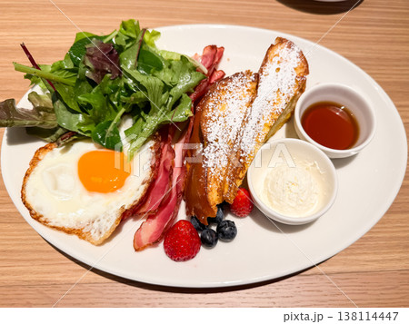 フレンチトーストとベーコンと目玉焼きが乗ったプレート料理。 138114447