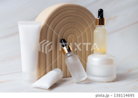 Skincare cosmetic products with serum dropper bottles and cream containers on minimal beige podium, beauty skincare routine concept Skincare cosmetic products with serum dropper bottles and cream containers on minimal beige podium, beauty skincare routine concept 138114695