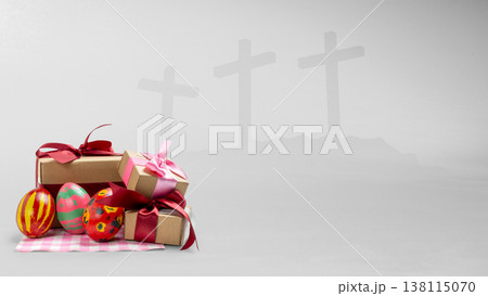 Festive Easter eggs and gift boxes in the foreground with a symbolic background of three crosses on a hill, representing the religious and celebratory aspects of the holiday 138115070