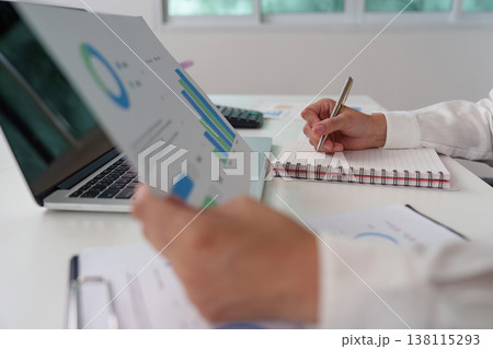 Accountant reviewing financial charts and taking notes 138115293