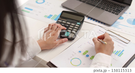 Accountant calculating data with charts and graphs Accountant calculating data with charts and graphs 138115313