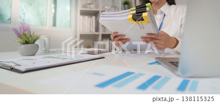 Accountant organizing financial reports in an office Accountant organizing financial reports in an office 138115325