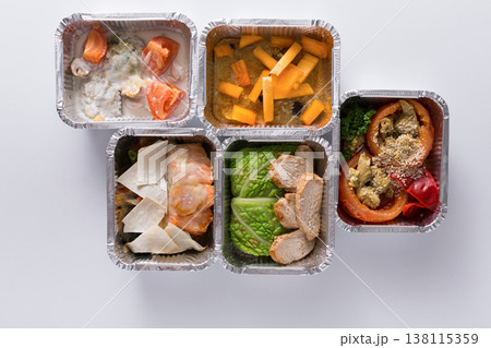 Healthy food delivery. Take away of natural fitness dishes for diet. Daily meals in foil boxes on white background Healthy food delivery. Take away of natural fitness dishes for diet. Daily meals in foil boxes on white background 138115359