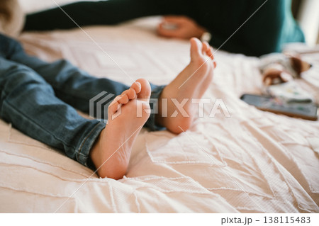 Relaxed Child Lying on Bed with Bare Feet Showing Relaxed Child Lying on Bed with Bare Feet Showing 138115483