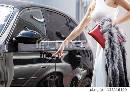 Fashionable woman opening car 138116109