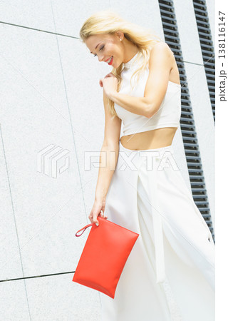 Fashion woman white outfit with red handbag 138116147