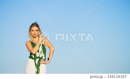 Woman in summer long dress against blue sky Woman in summer long dress against blue sky 138116167