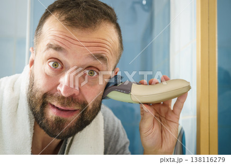 Man shaving trimming his beard 138116279