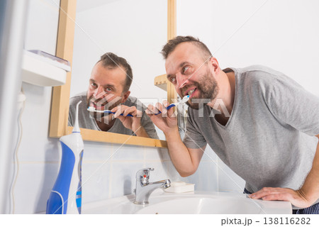 Man brushing his teeth in bathroom 138116282