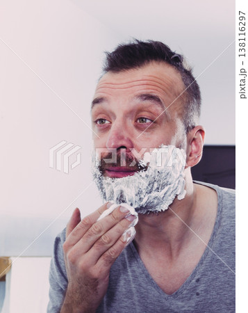 Man applying shaving cream on beard 138116297