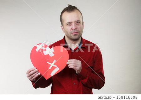 Sad adult man holding broken heart 138116308