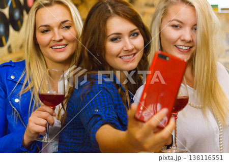 Girls in pub club taking self photo with phone Girls in pub club taking self photo with phone 138116551