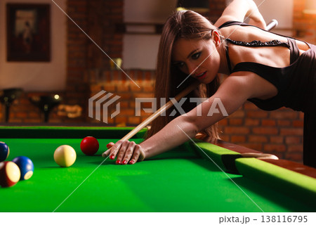 Young woman playing billiard. Young woman playing billiard. 138116795