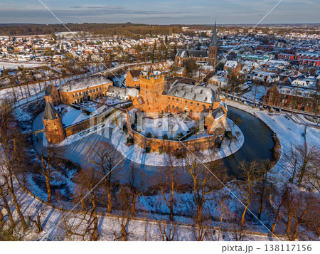 Aerial view of the medieval Huis Bergh Castle in s-Heerenberg, Netherlands. A stunning winter scene with a snow covered fortress, frozen moat, and a charming European town during golden hour. 138117156