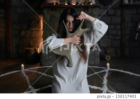 Woman performs arcane spell exorcism rituals, candlelit fortress surroundings Woman performs arcane spell exorcism rituals, candlelit fortress surroundings 138117401