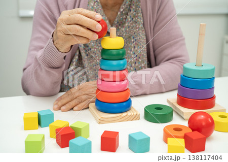 Alzheimer disease AD, Asian elderly woman patient suffering from dementia learn practical motor skills rehabilitation. 138117404