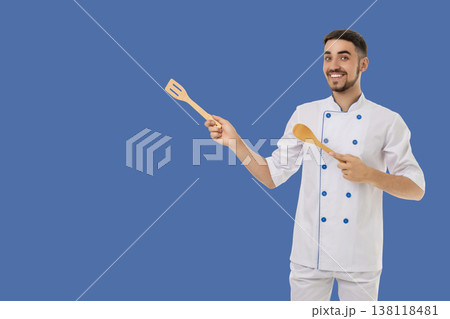 Occupation, Man in chef outfit shows cooking tools and smiles 138118481