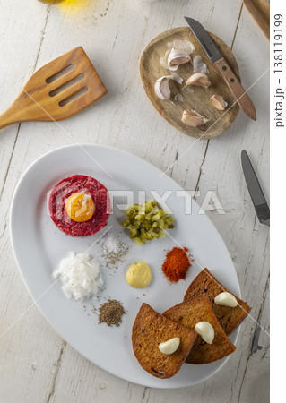 Steak tartare dish serving raw beef and ingredients 138119199